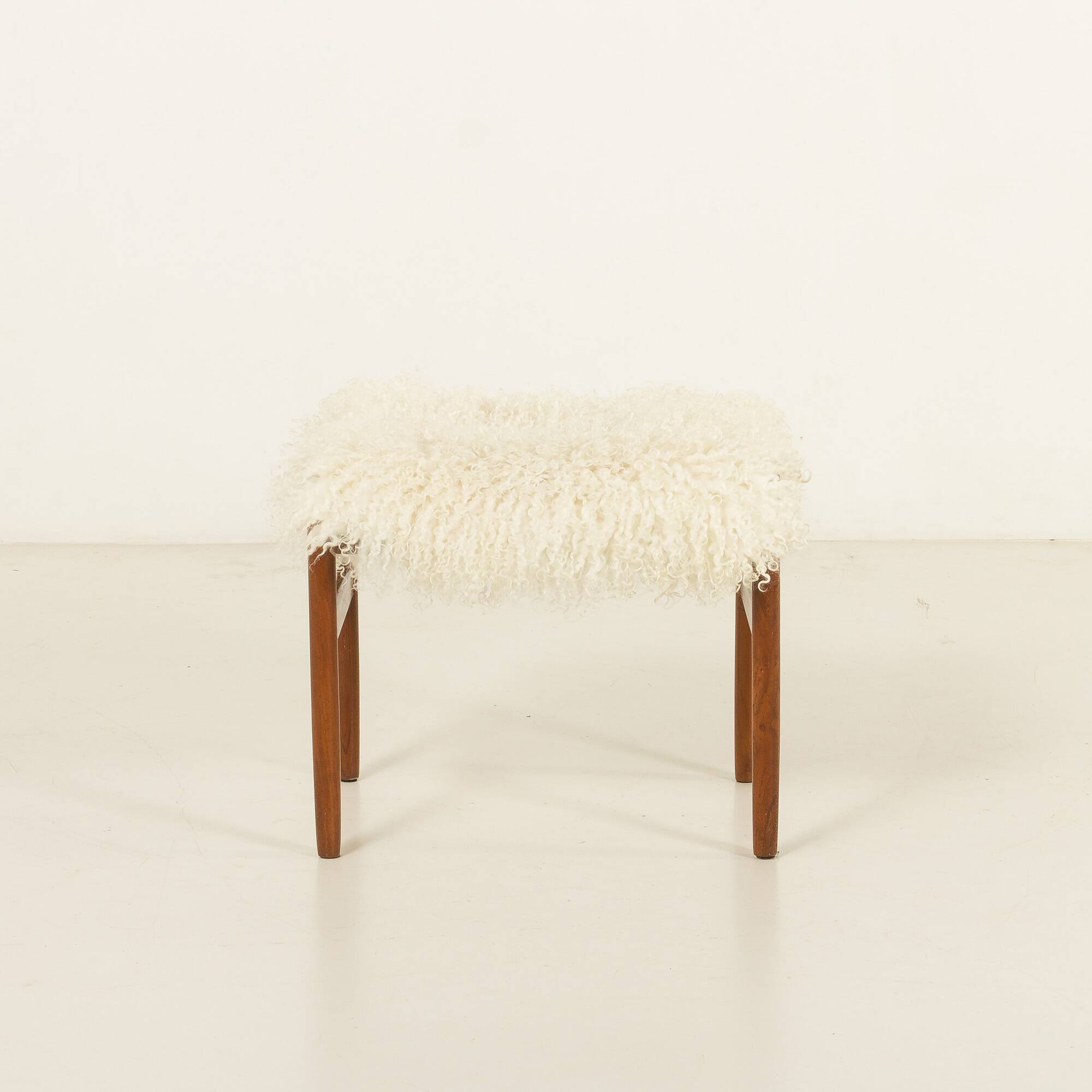 Pouf en teck danois des années 60 recouvert de peau de mouton à poils longs.