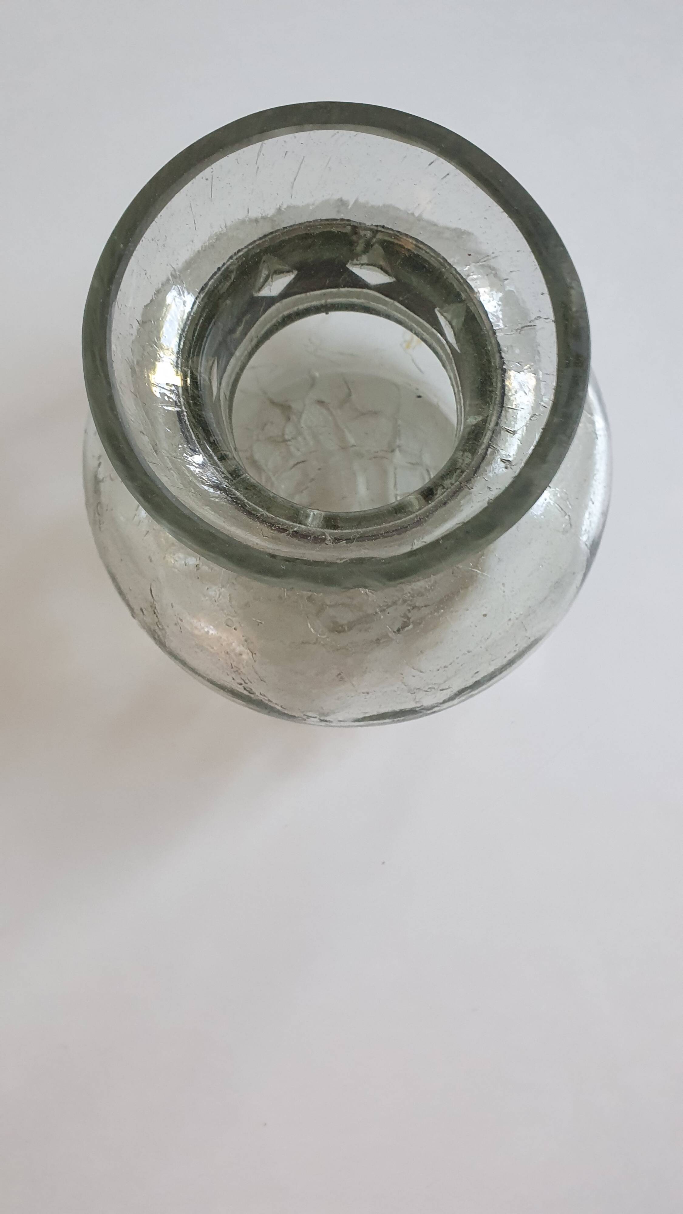 Cracked glass vase encircled with wrought iron.