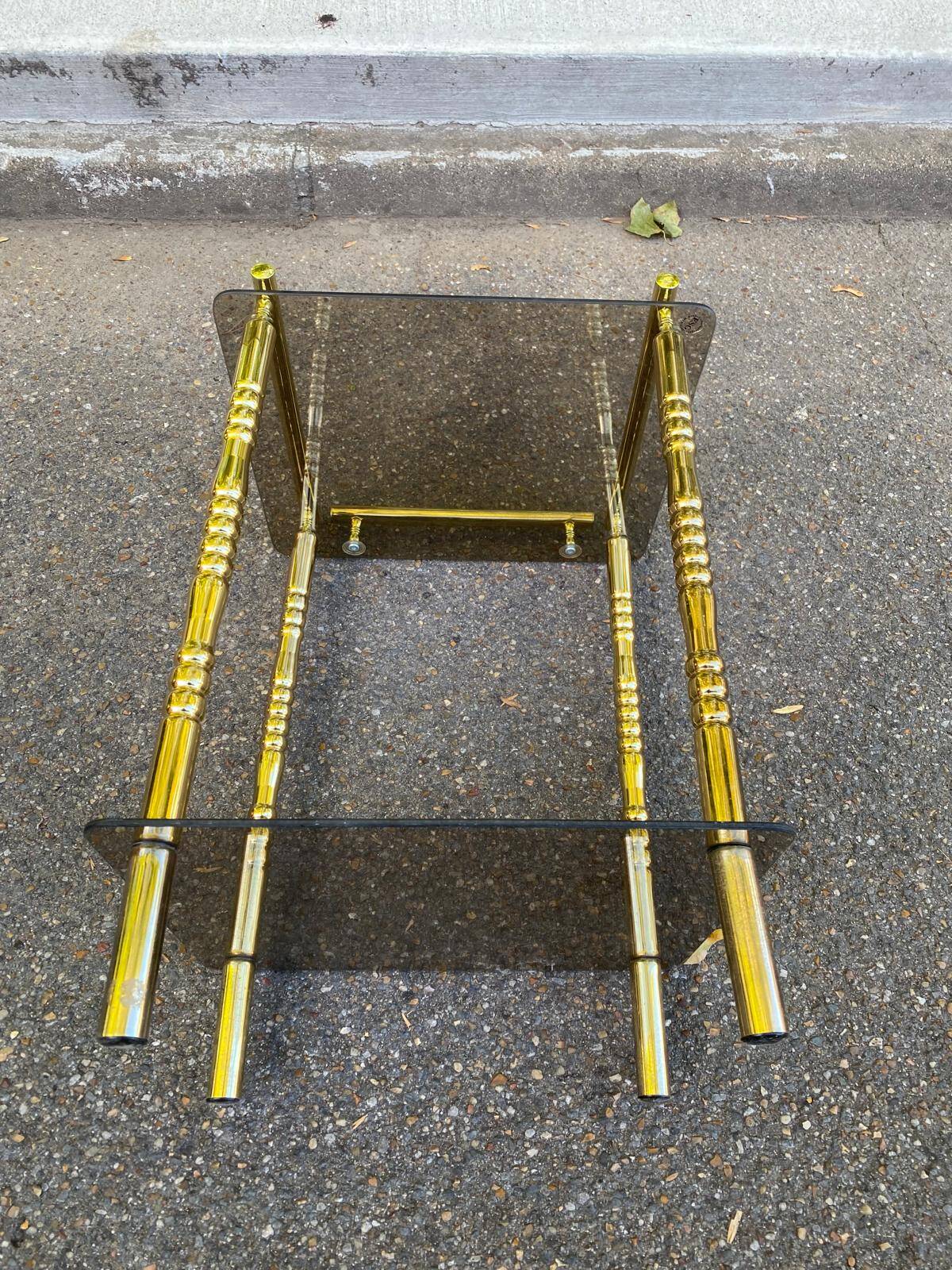 Vintage side table with smoked glass and sculpted golden brass, Hollywood Regency style.