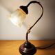 Gold swan neck table lamp with amber tulip glass.