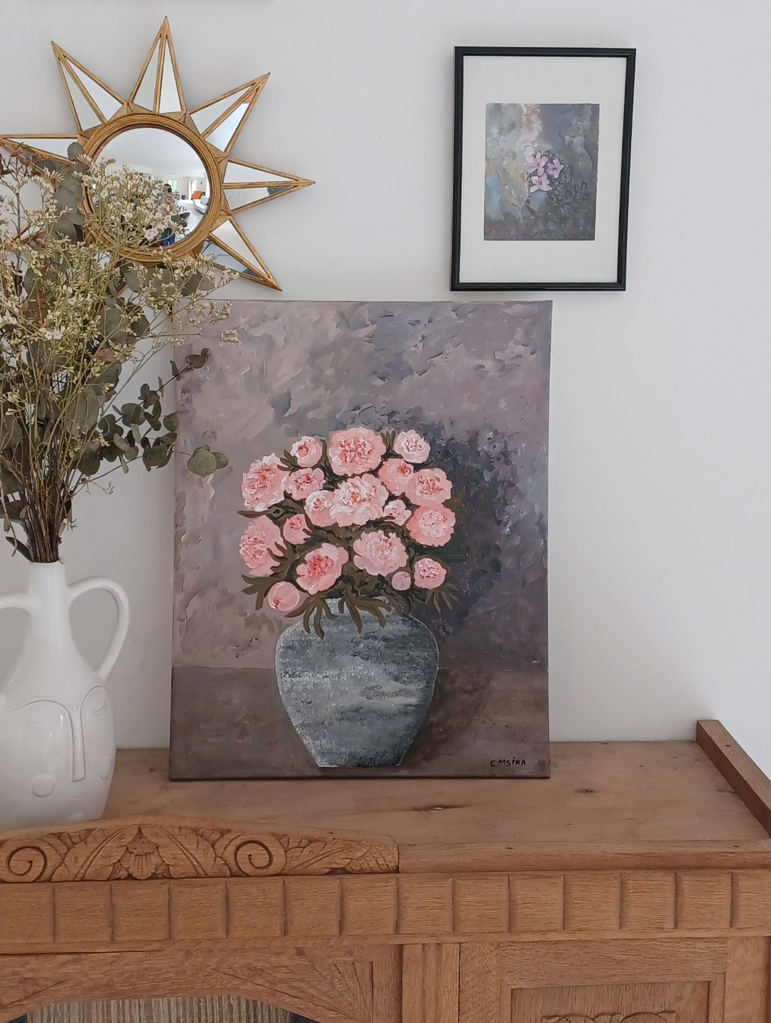Painting of a bunch of coral-colored peonies in a gray vase