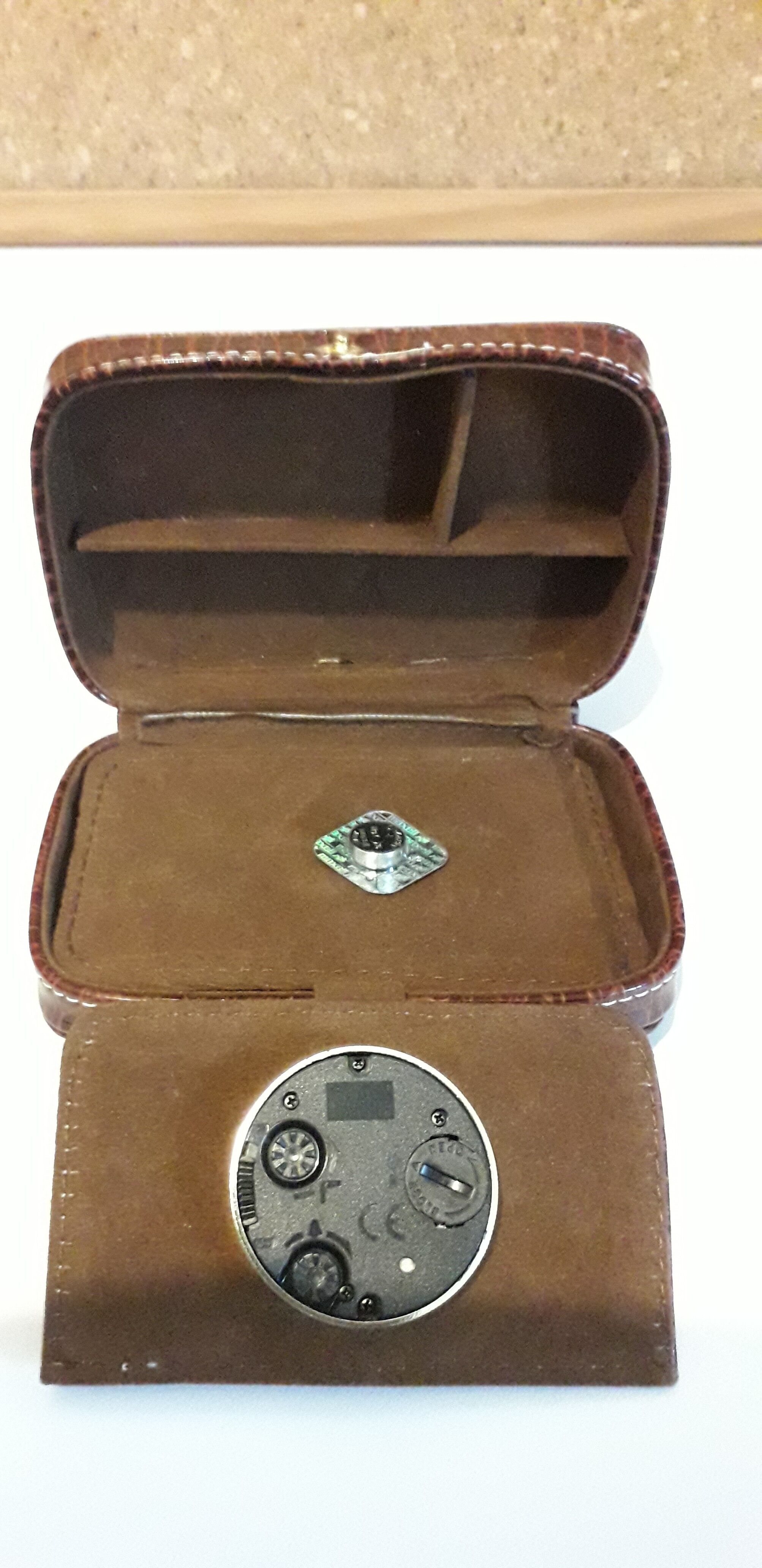 Small travel alarm clock in its case with jewelry compartments