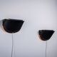 Matte black wall lamps with perforated shades and brass details