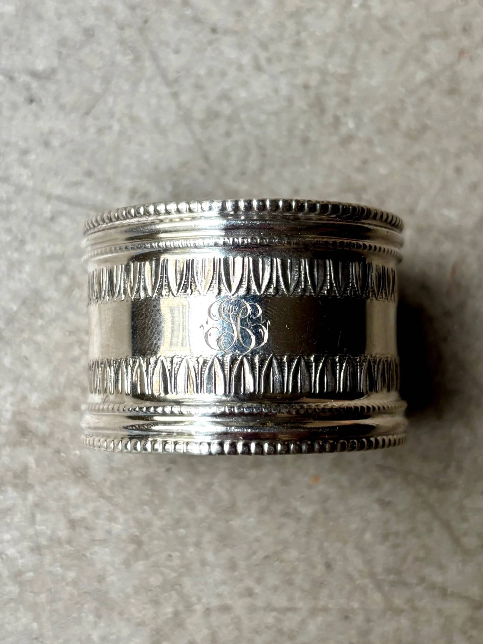 Monogrammed silver napkin ring with palmette and beaded motifs