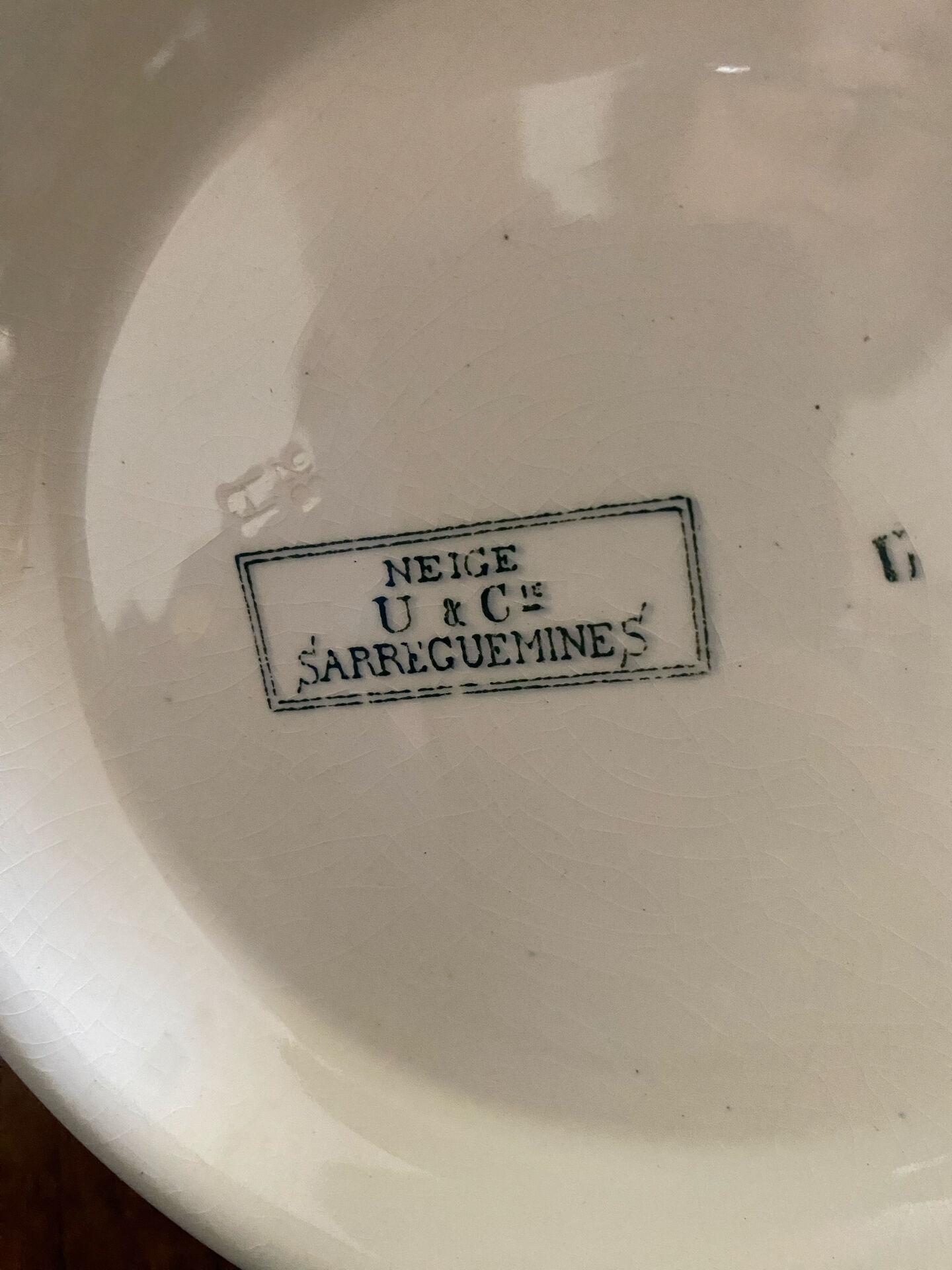 Plate on a presentation stand stamped U&C Sarreguemines Neige.