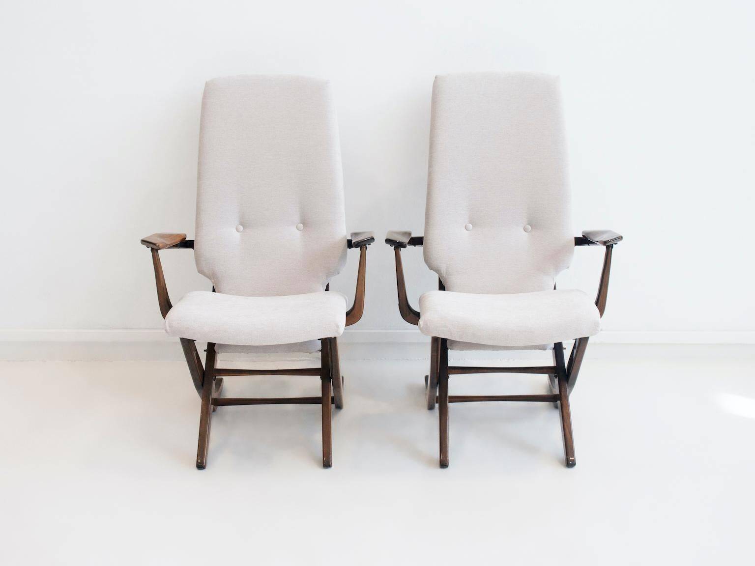Pair of varnished wooden reclining armchairs, upholstered in lightweight fabric.
