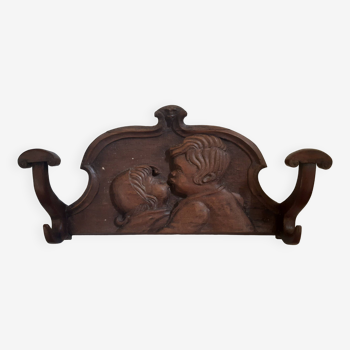 Old solid wood coat hook with carved children's motifs