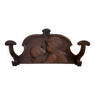 Old solid wood coat hook with carved children's motifs