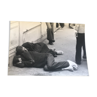 Photographie années 90, deux hommes allongés dan la rue