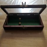 Magnifying glass and paper cutter in a vintage wooden box