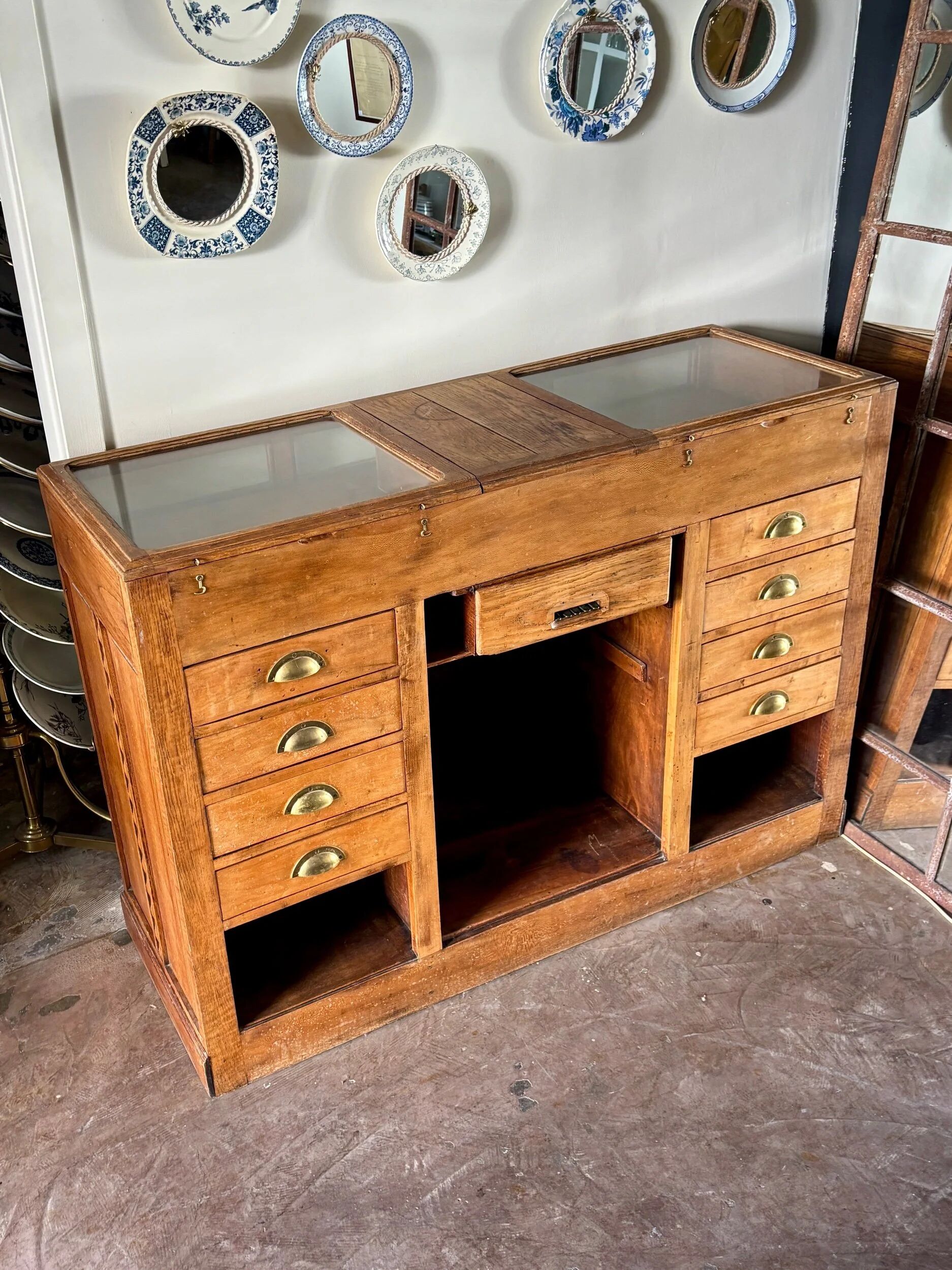Counter, glass-fronted wooden workbench in dark wood, 8 drawers.