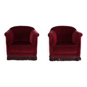 Pair of curved Danish lounge chairs from the 1950s in deep red velvet with fringes.
