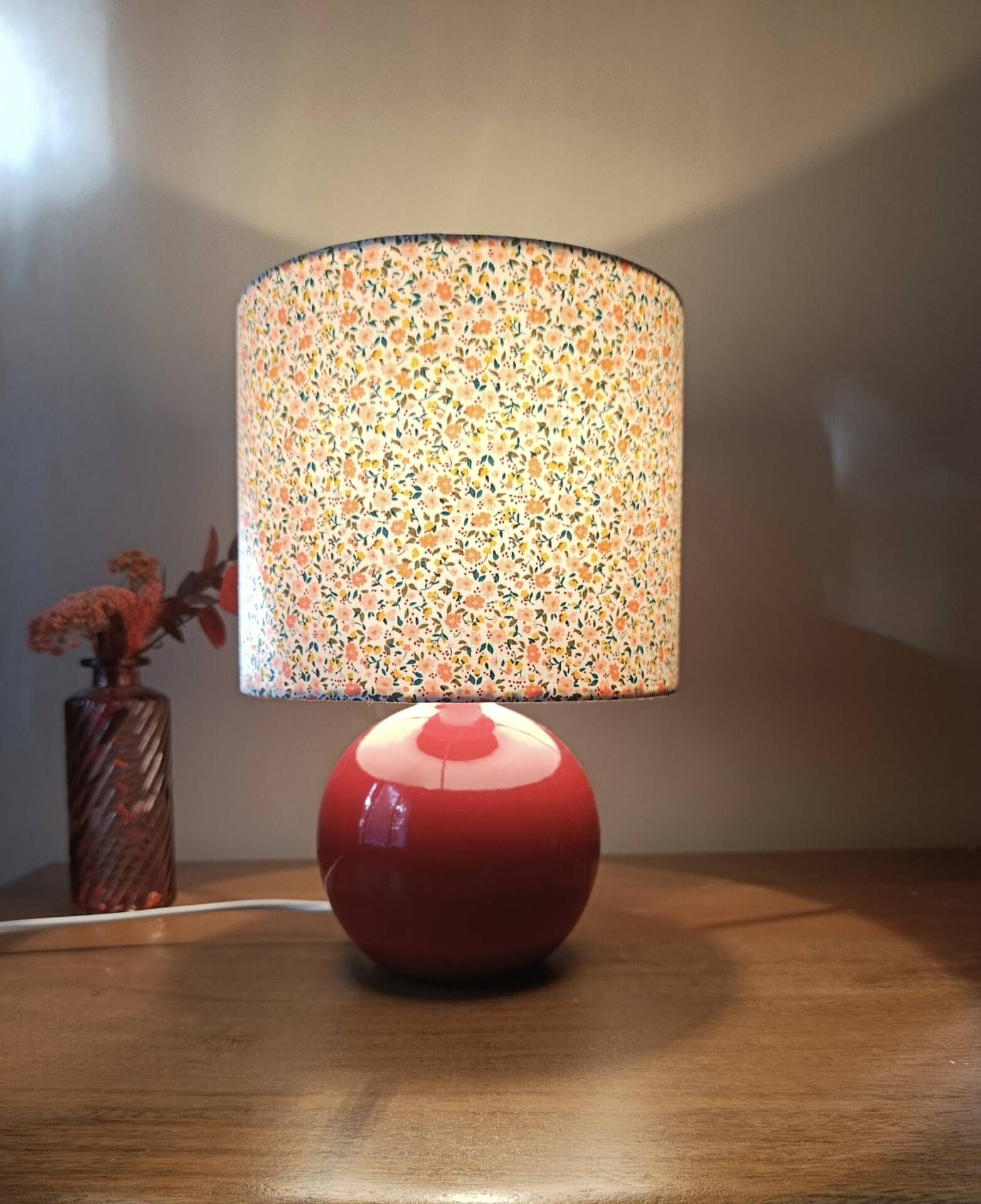 Red bedside lamp, liberty lampshade with small pink flowers.