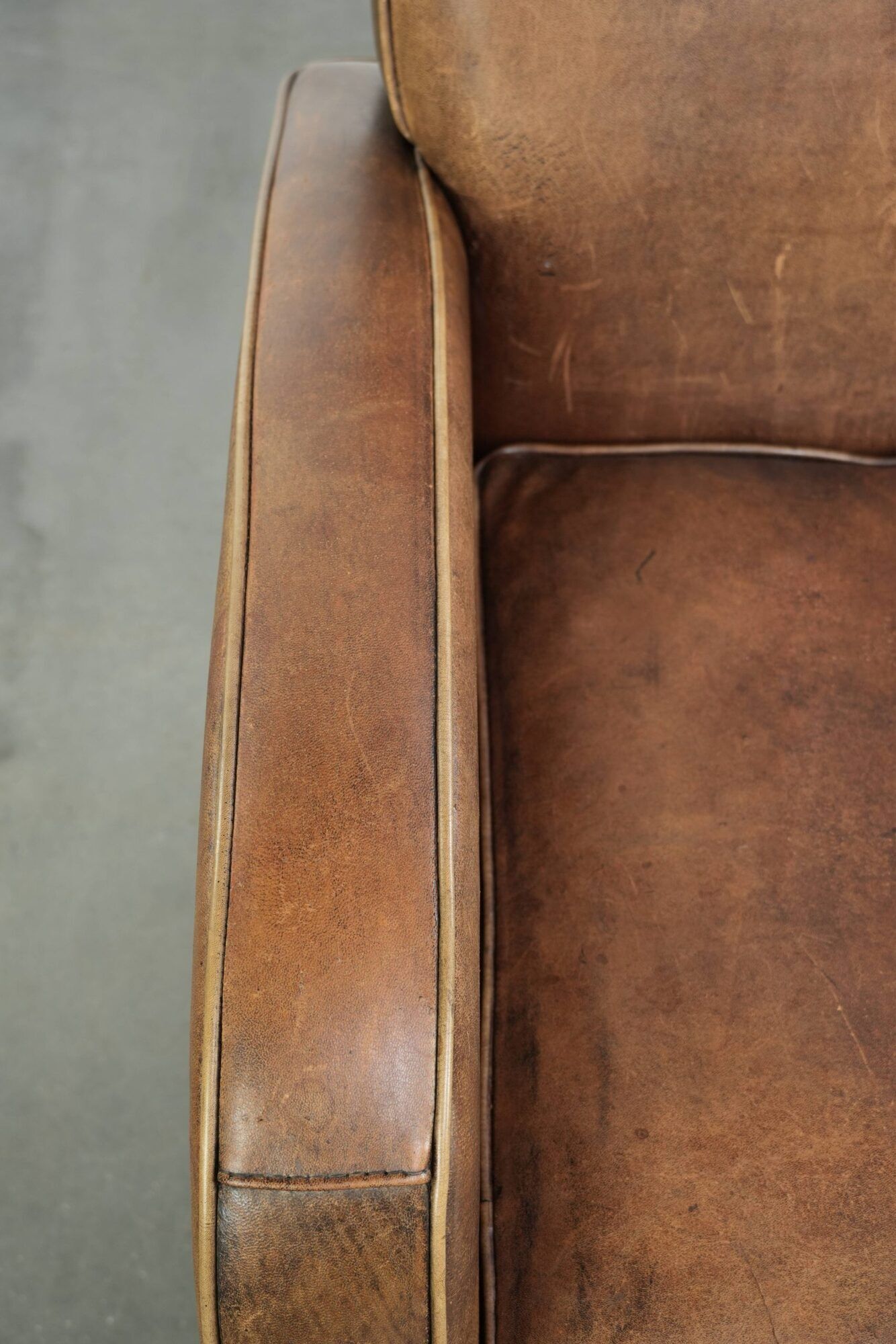 Sheepskin armchair in a light cognac colour with matching piping