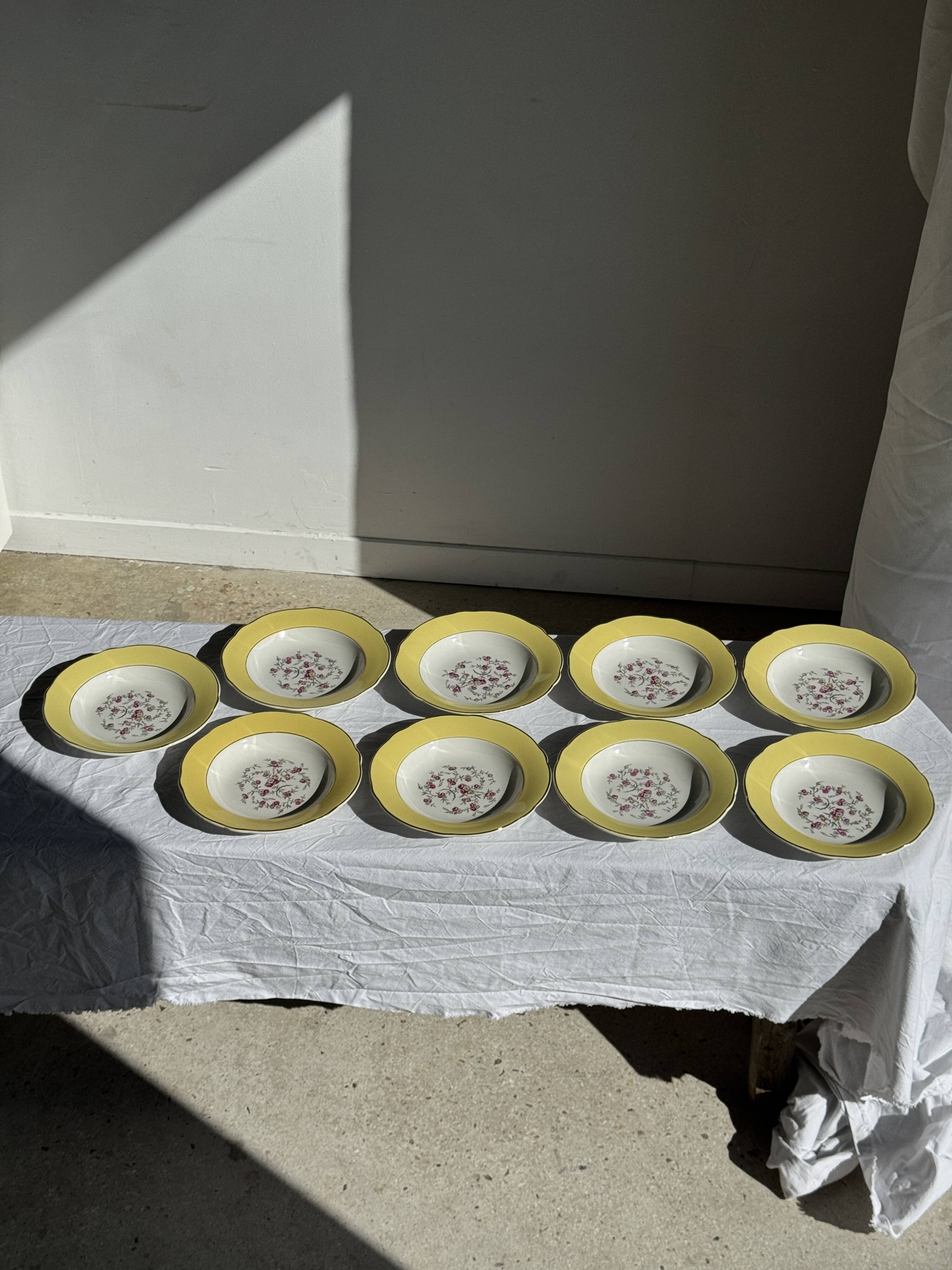 Set of 9 large vintage yellow deep plates with pink flowers and a gold rim.