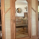 Large antique wardrobe made of solid raw wood and natural caning.