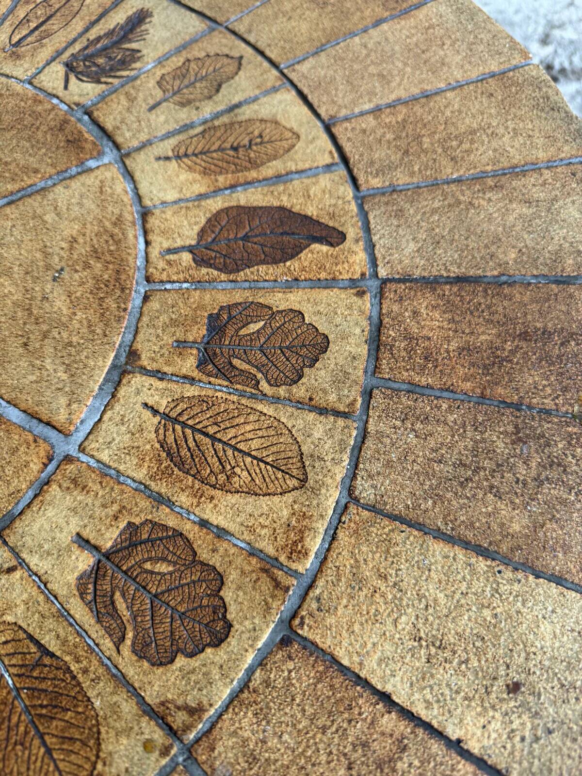Roger Capron brown-ochre ceramic tile coffee table with wooden base, oval leaf-motif top