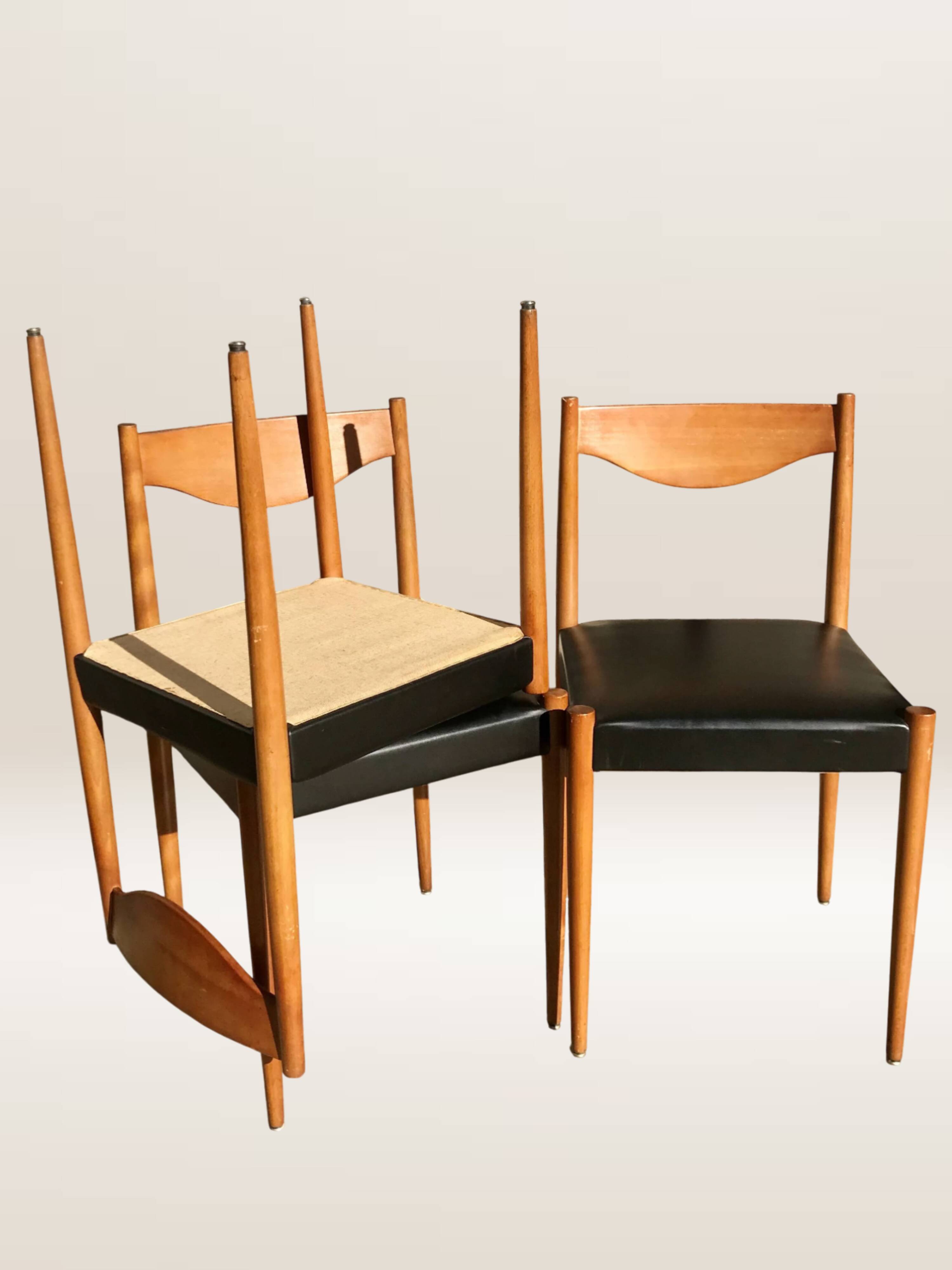 Set of 6 modernist chairs with black faux leather seats.