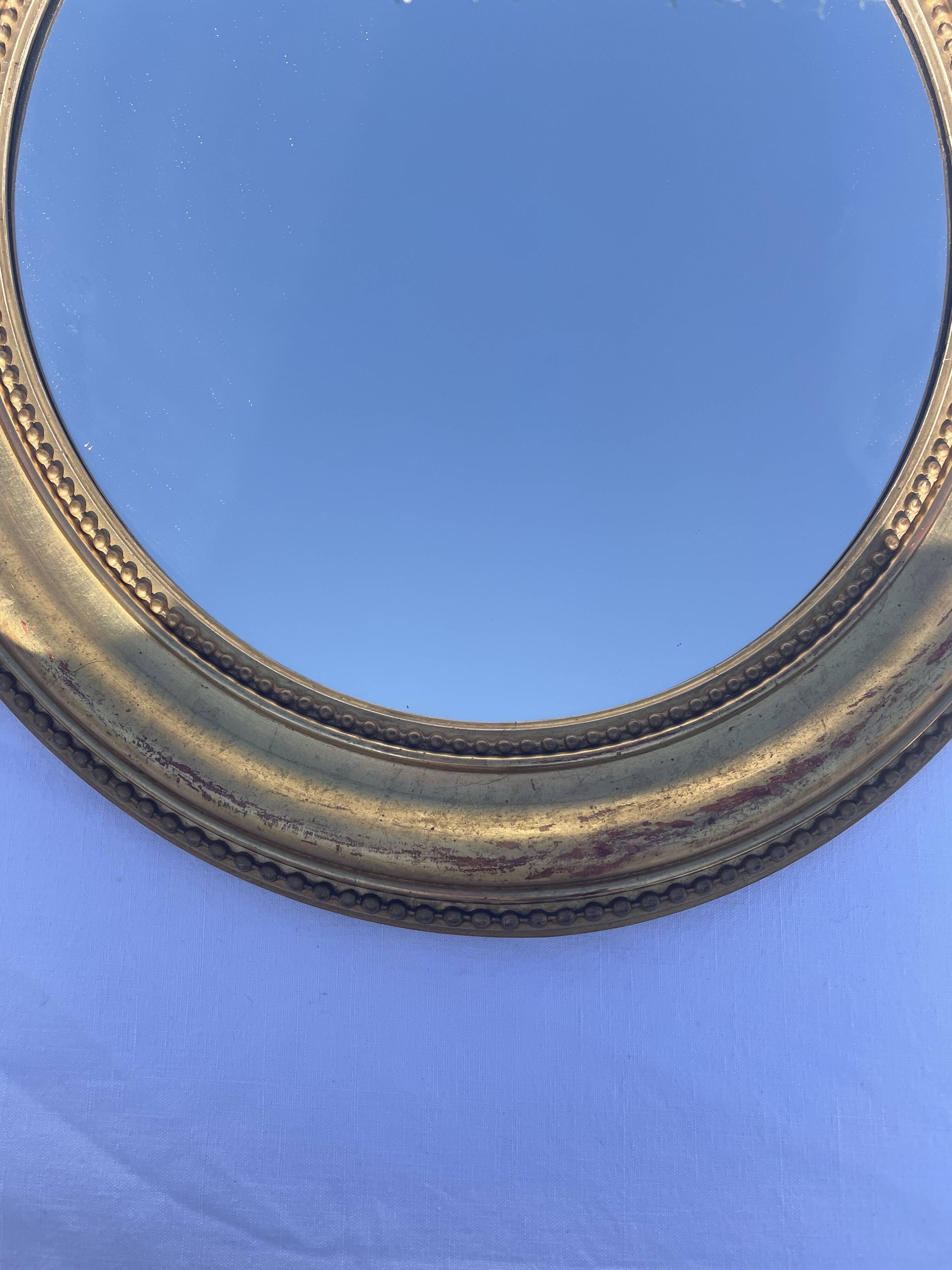 Duo de miroirs ovales et dorés en bois