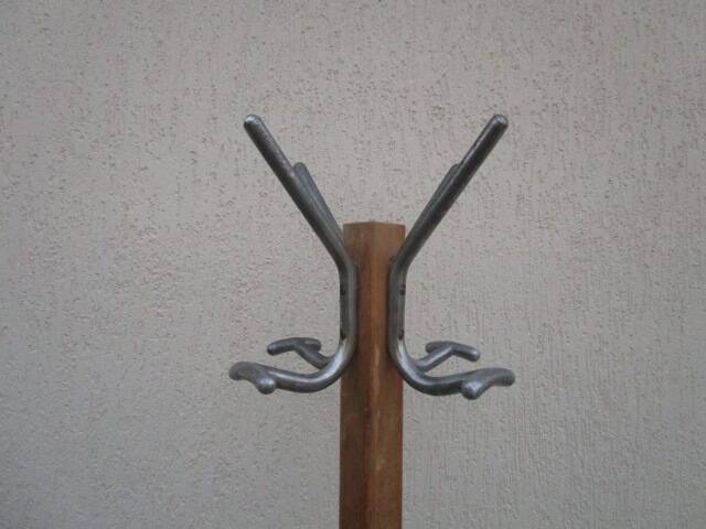 Antique light wood coat rack with splayed legs.