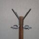 Antique light wood coat rack with splayed legs.