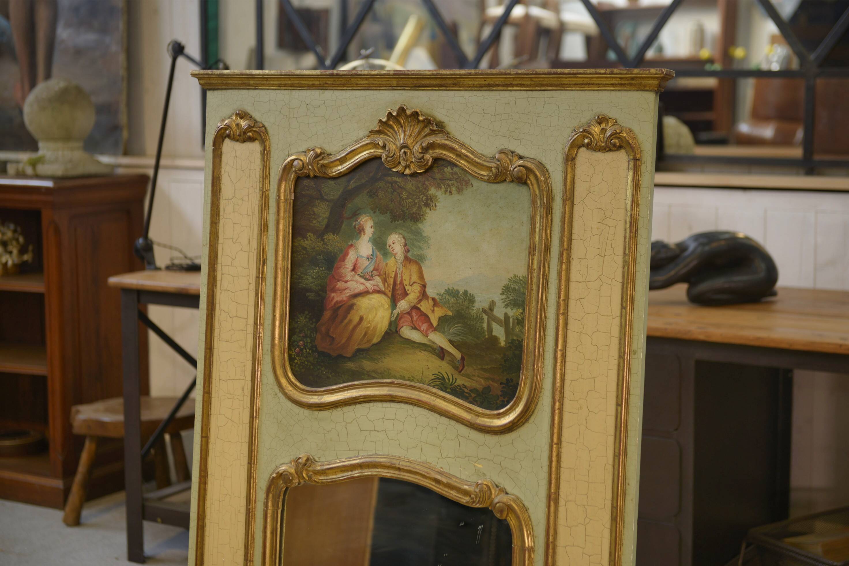 Trumeau mirror with cracked patina and oil on panel depicting a romantic scene from the 19th century.