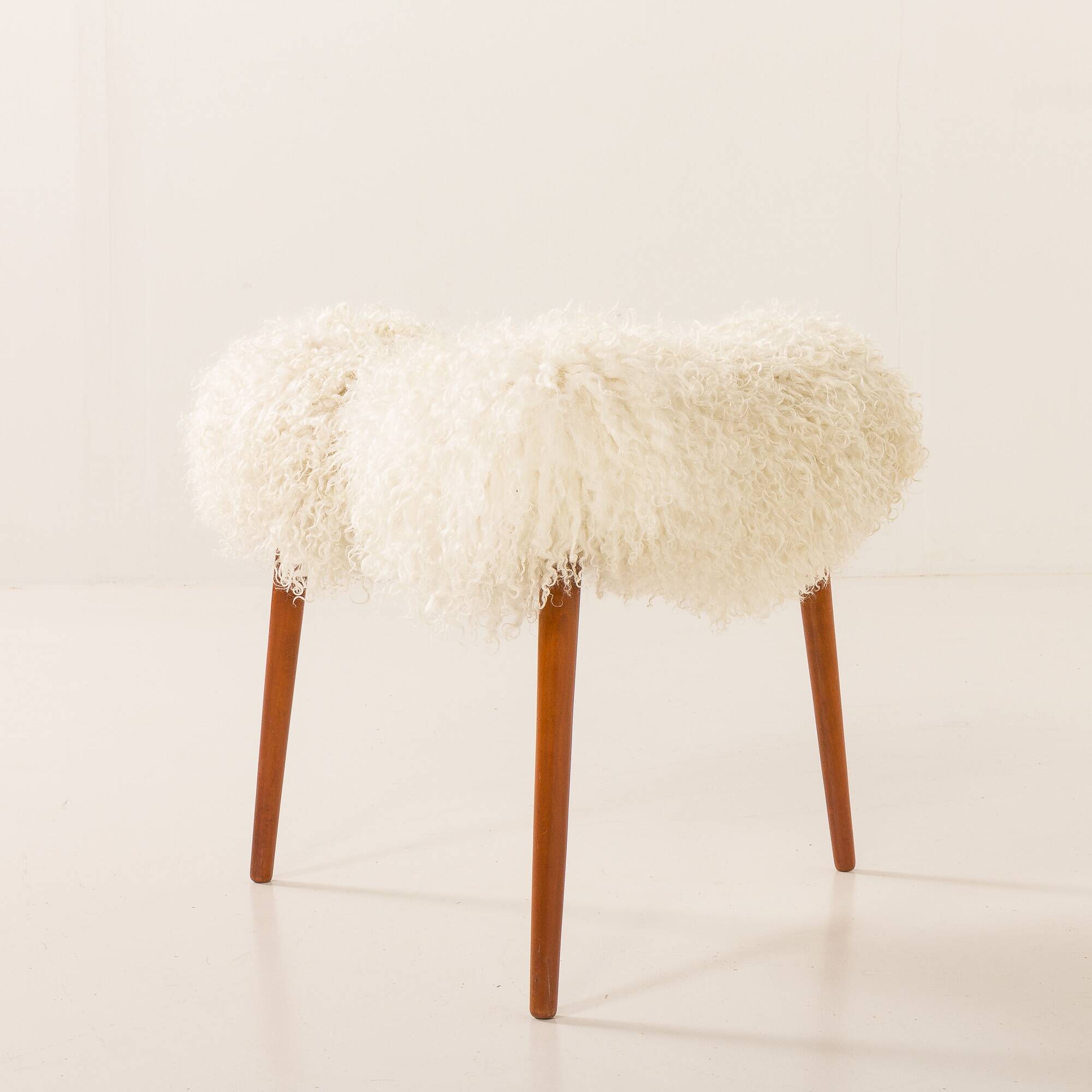 Scandinavian mid century triangular footstool in long hair sheepskin