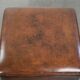 Large dark brown square ottoman made of sheepskin with black piping