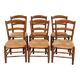 Set of six rustic chairs in natural wood with straw seats.