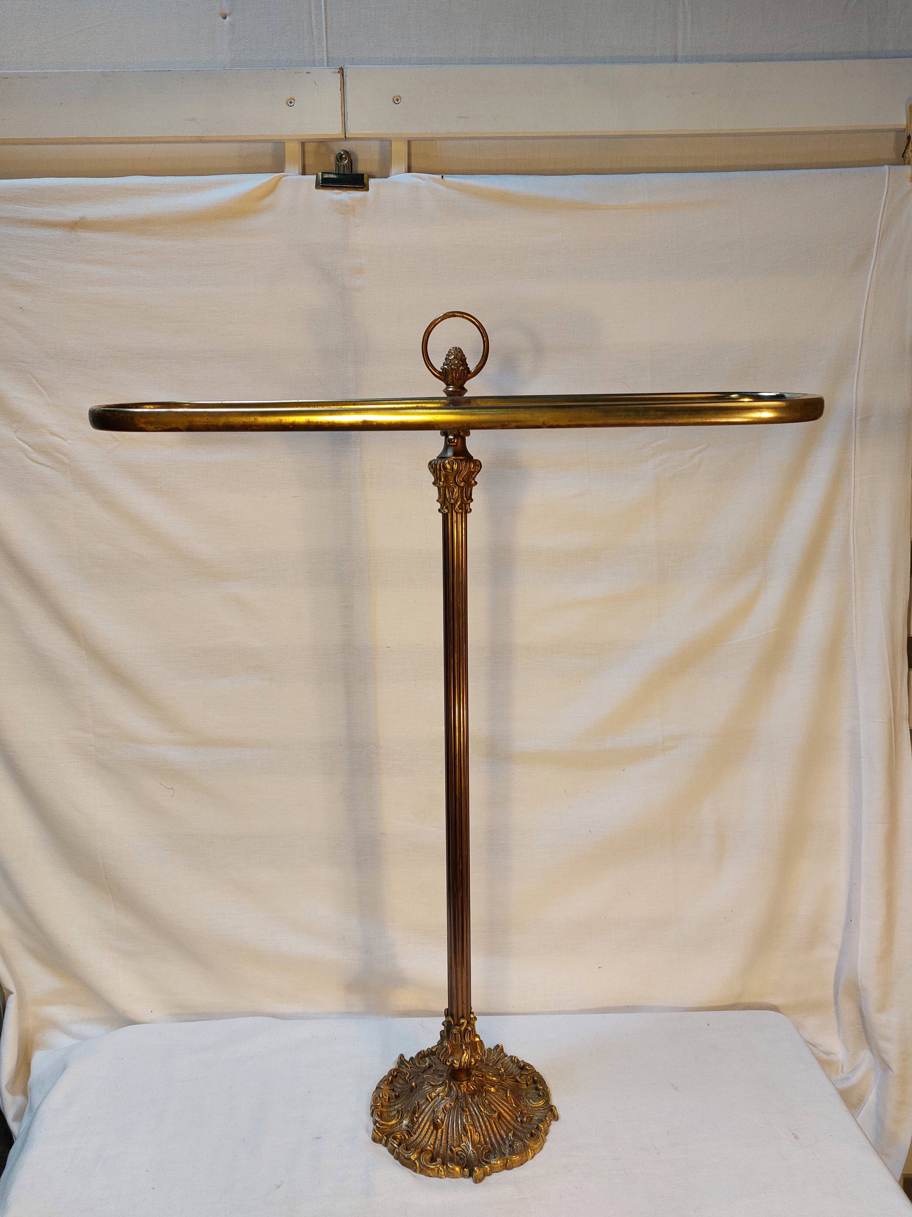 Old golden brass towel rack on baroque style foot