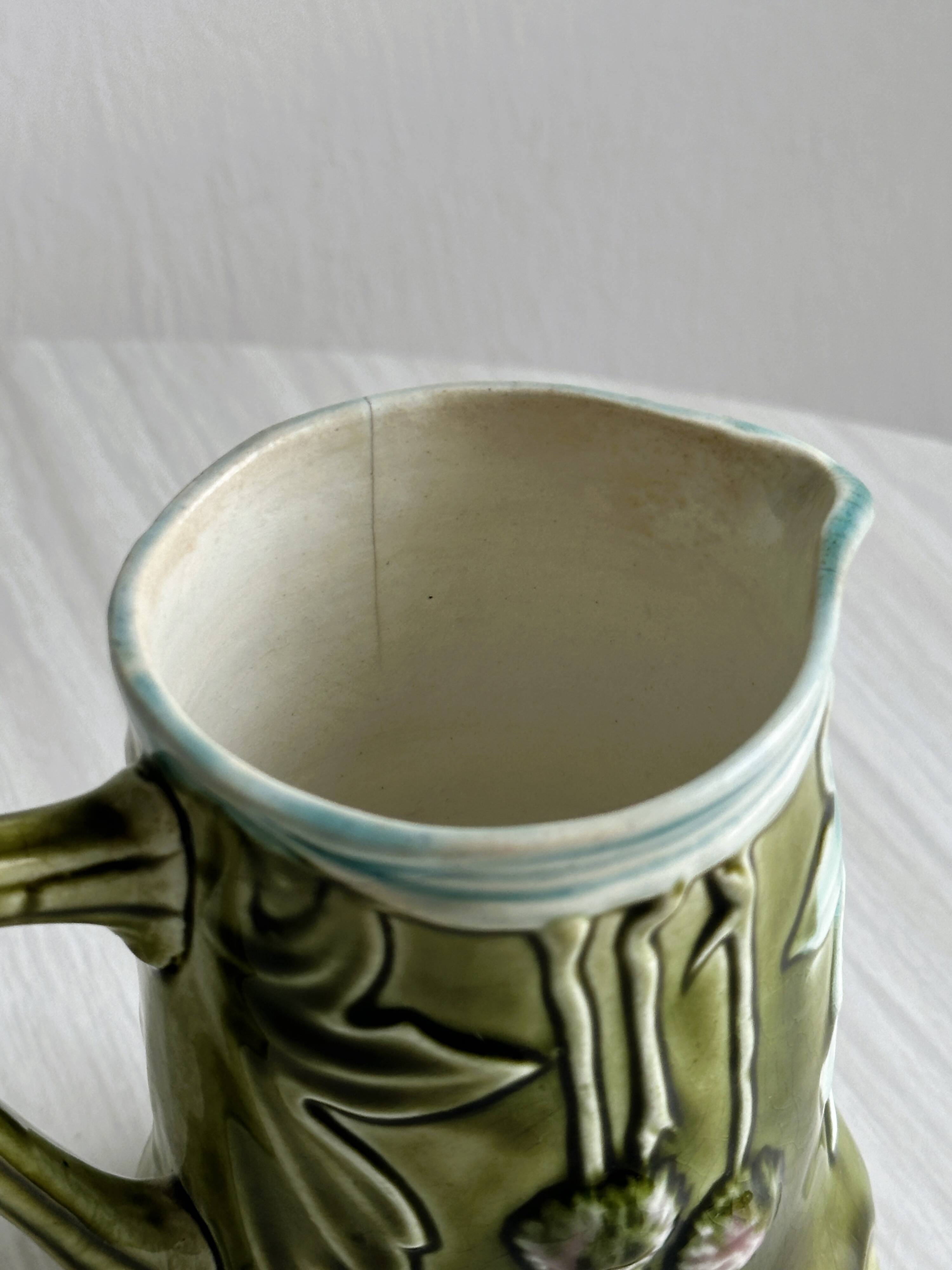 Green slip milk jug with floral patterns.