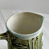 Green slip milk jug with floral patterns.