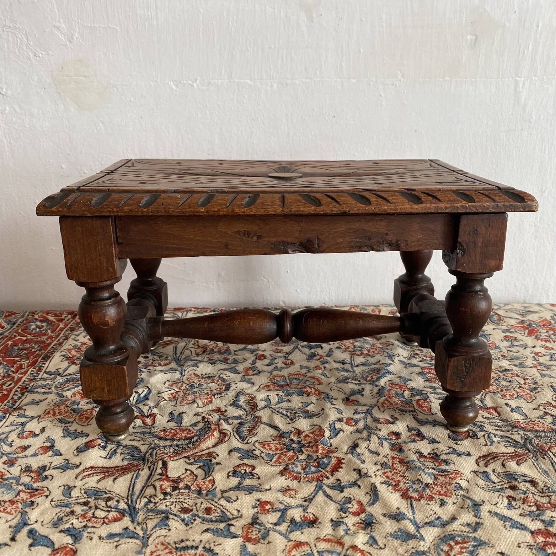 Low stool in carved wood