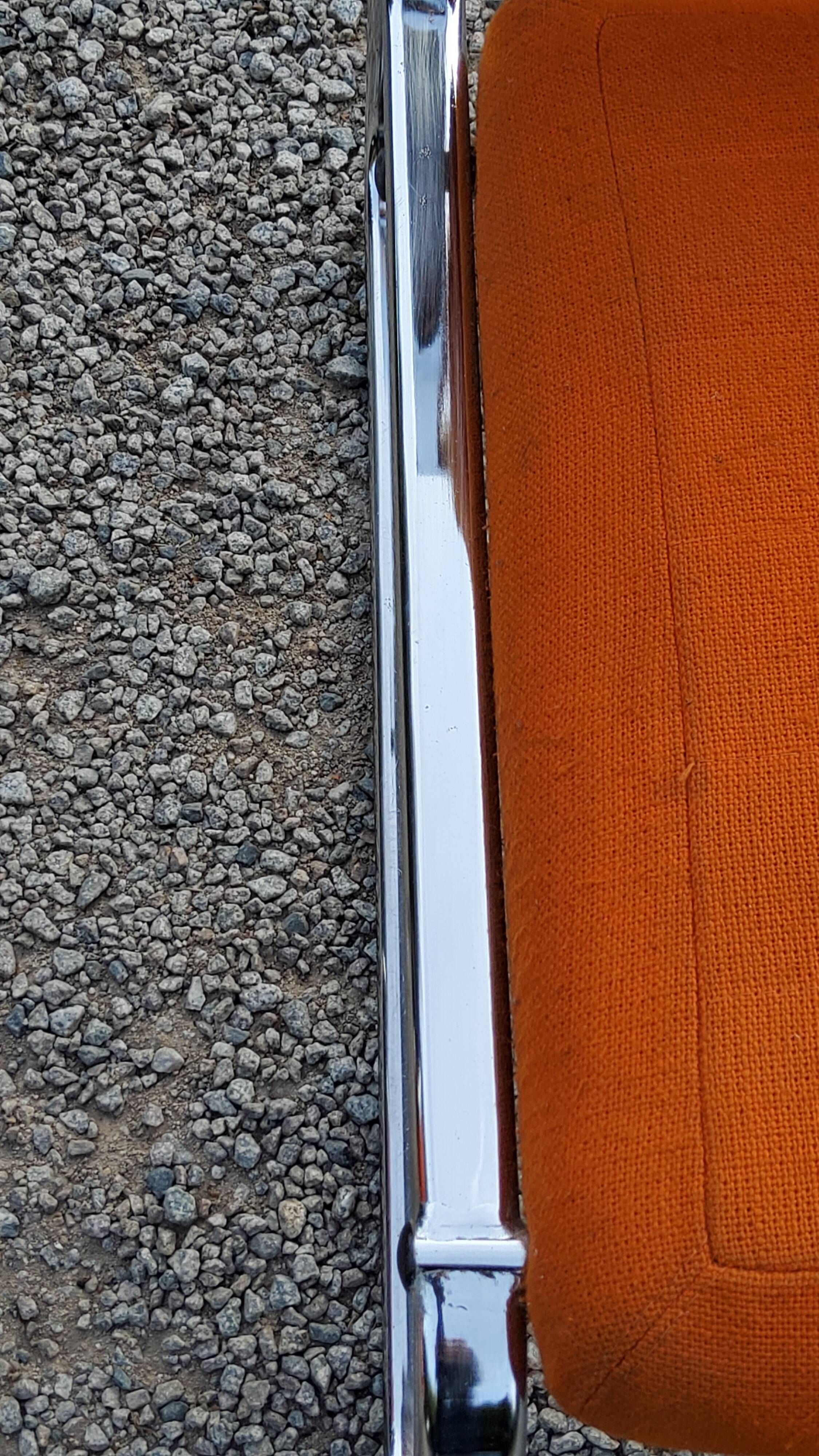 Pair of designer armchairs in orange fabrics and chrome tubes from the 70s