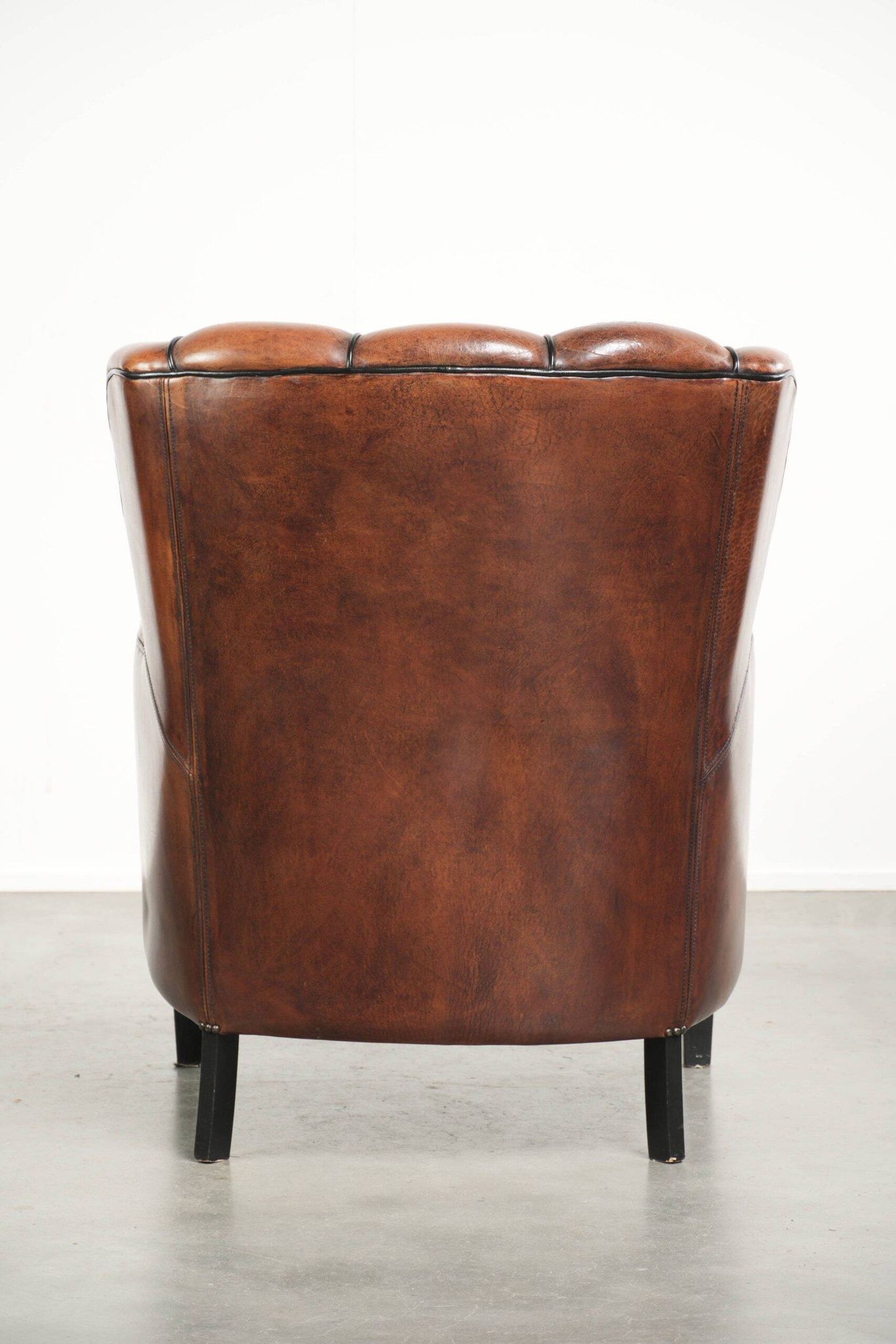 Unique sheepskin armchair with warm deep colours finished with black piping