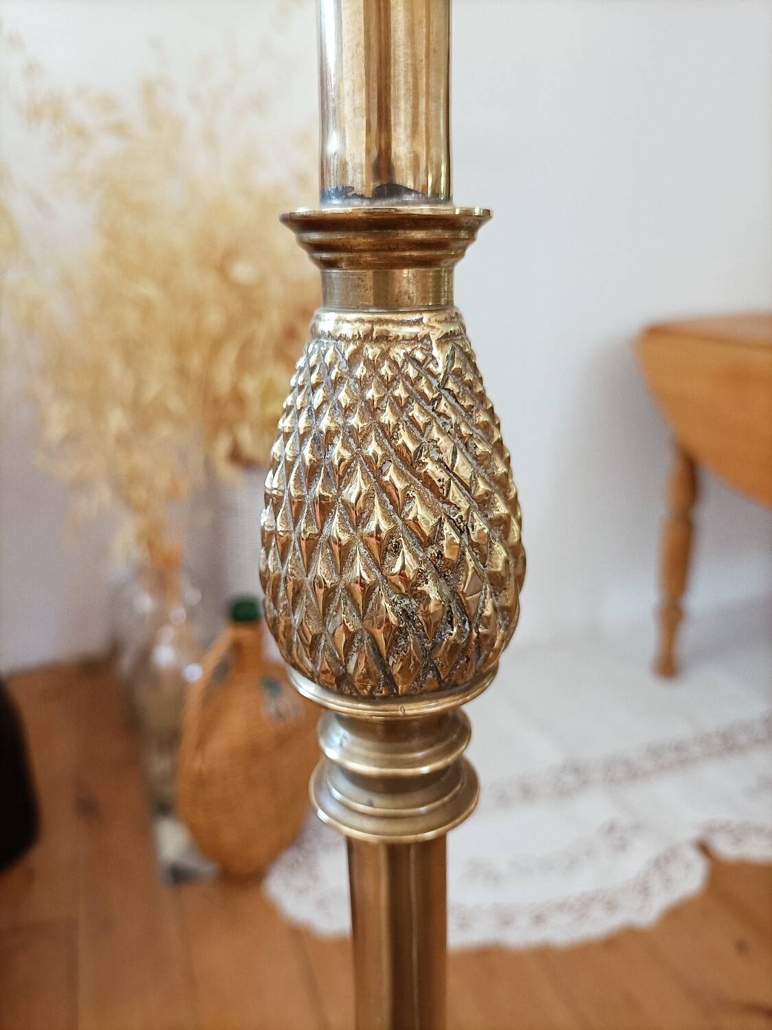 Bronze floor lamp with pine cone decoration.