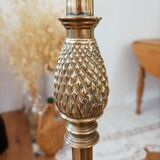 Bronze floor lamp with pine cone decoration.