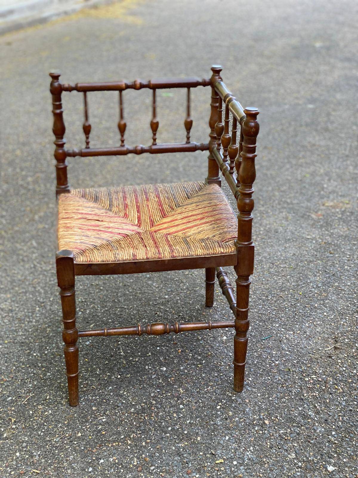 19th-century solid wood corner chair with red and blue rush seating.