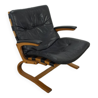 Zwart leren fauteuil met armleuningen en houten onderstel