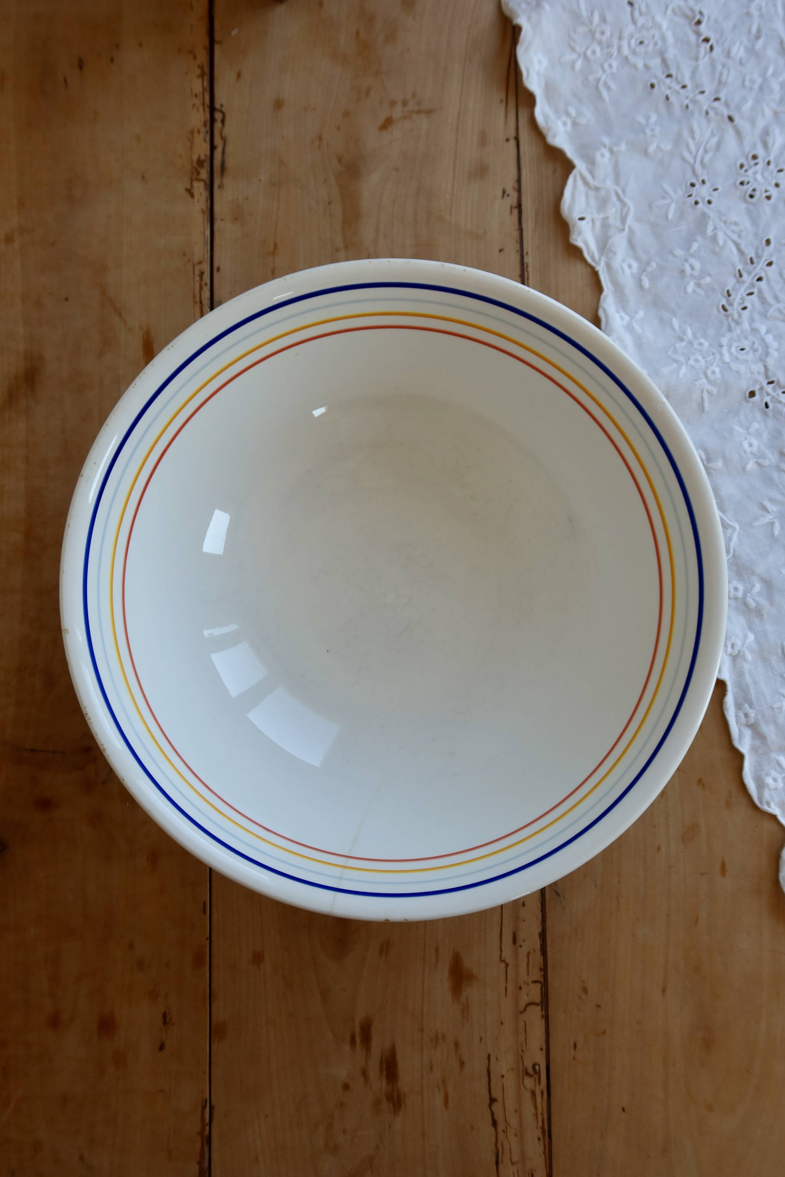 Vintage porcelain salad bowl with multicoloured borders.