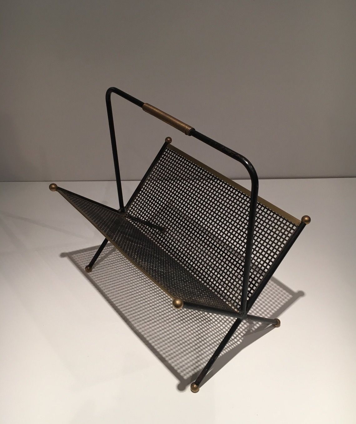 Black lacquered metal design magazine rack, perforated sheet and brass