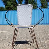 Old relax armchair in black metal and white plastic cannage