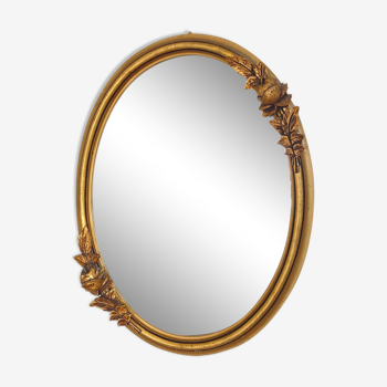 Oval mirror with a gilded frame and carved with bouquets of roses