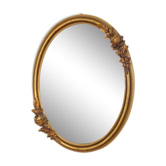 Oval mirror with a gilded frame and carved with bouquets of roses