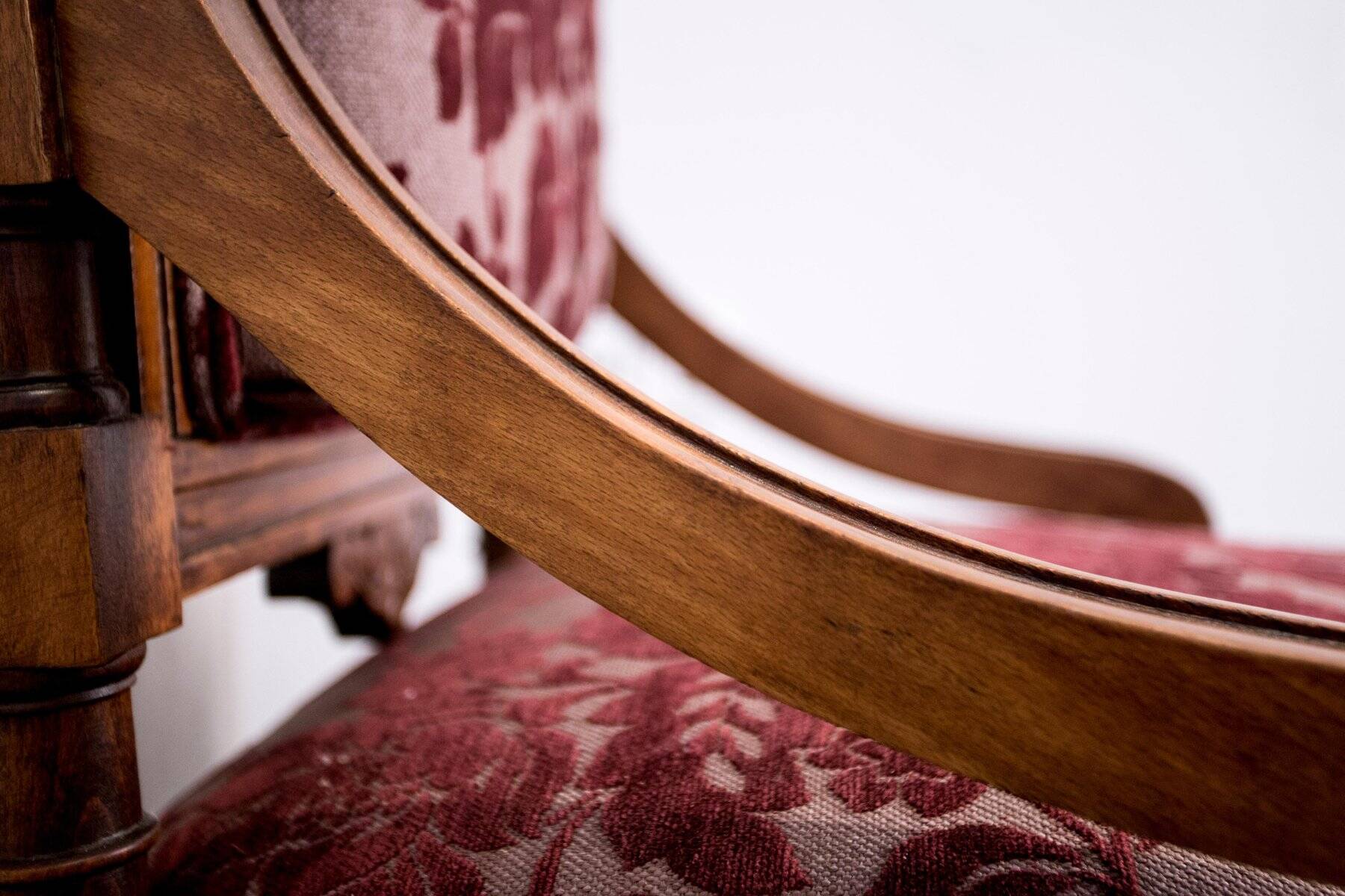 Antique lacquered wooden armchair with burgundy fabric, carved, before 1890.