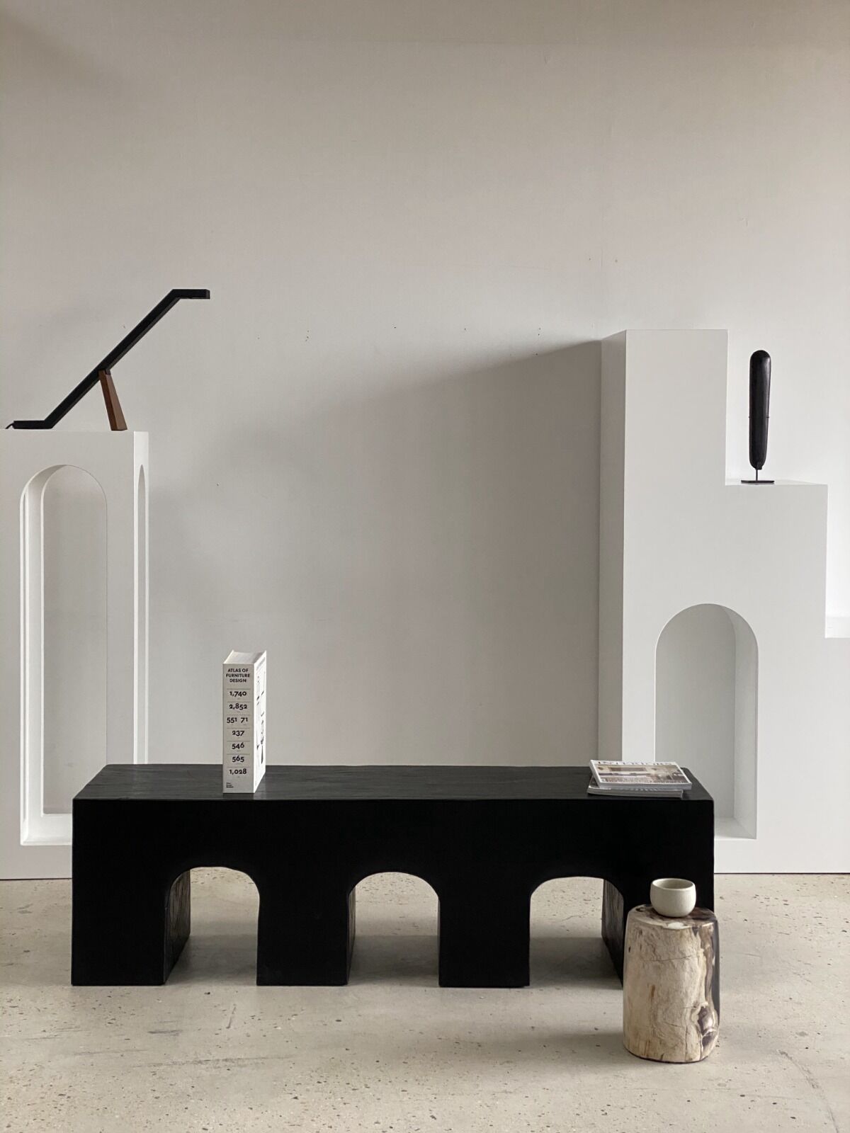 Black solid monoxyl wood bench carved into 3 arches