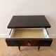 Vintage Art Deco bedside table in dark wood with gold details.