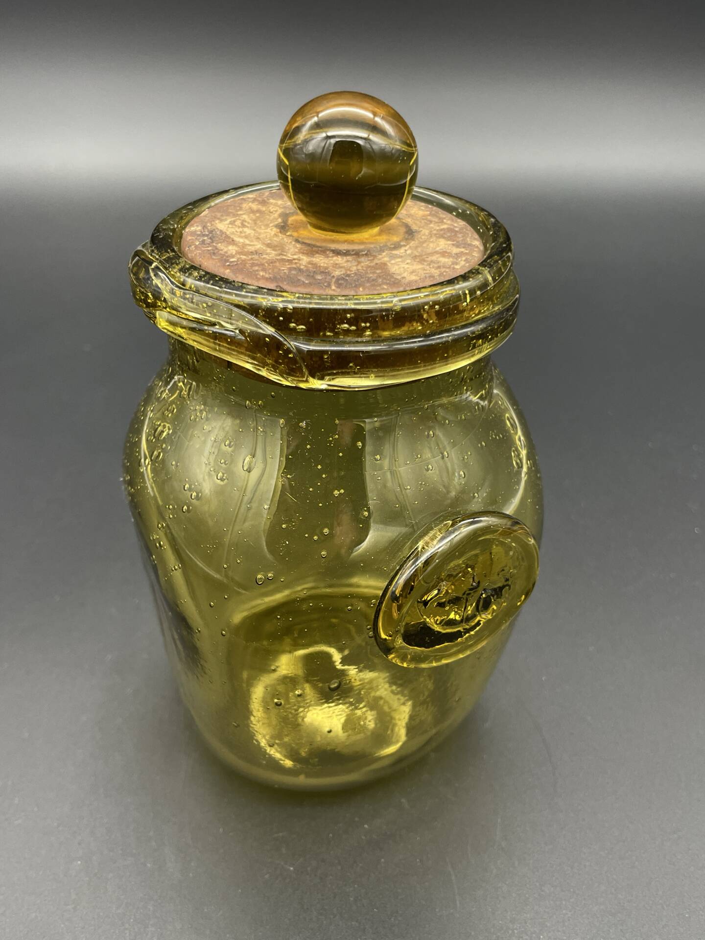 Yellow bubbled glass apothecary jar with cork lid.