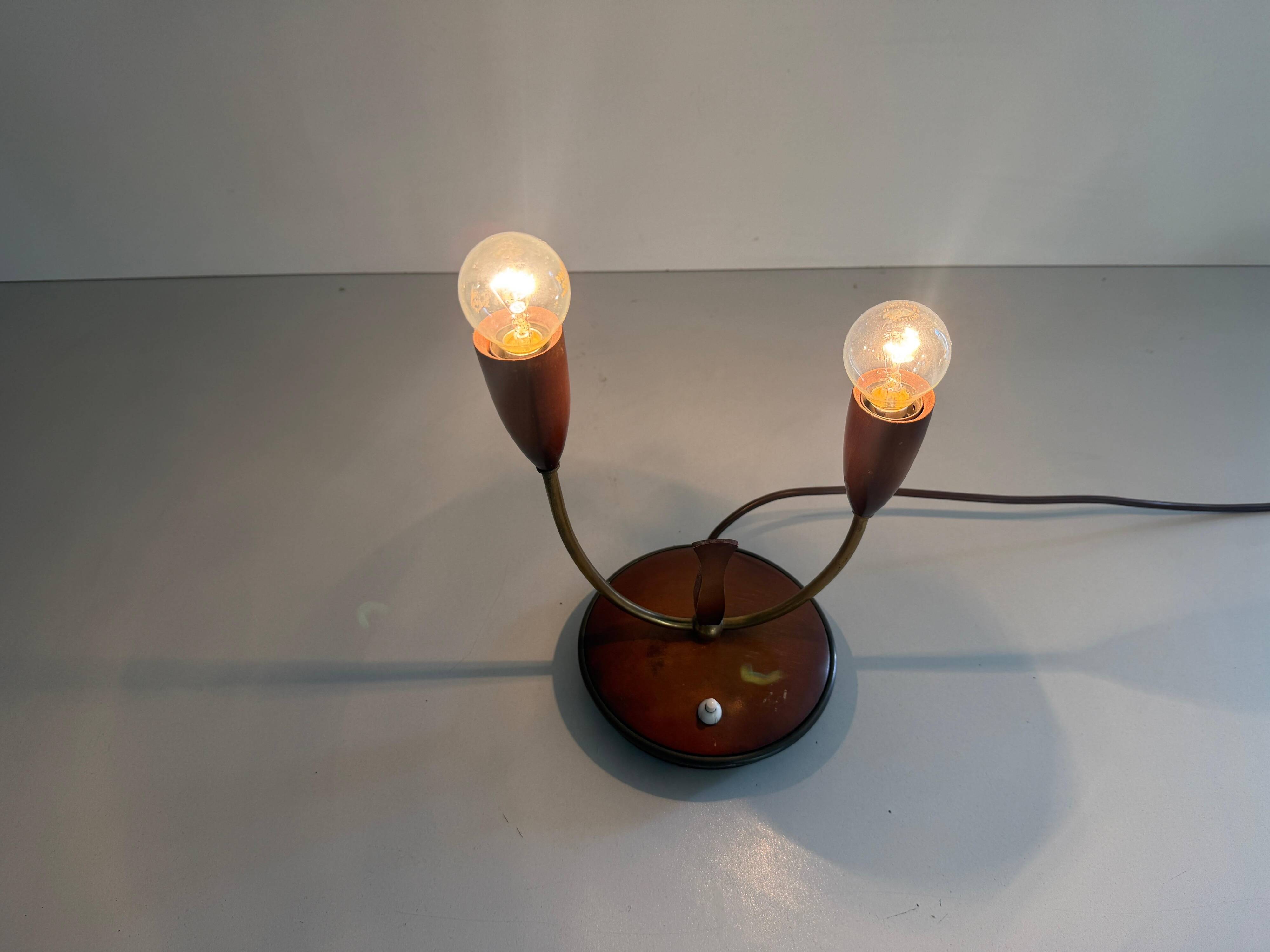 Simple double-headed table lamp in wood and brass, 1960s, Germany.