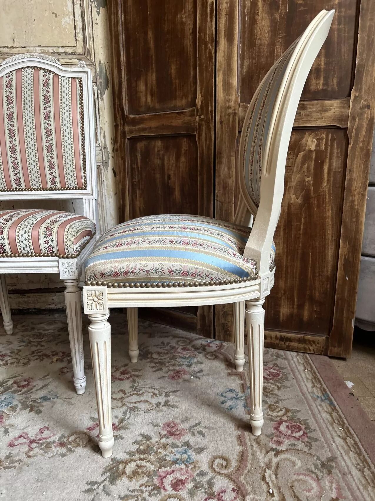 Pair of Louis XVI style chairs in painted wood and satin, classic elegance.